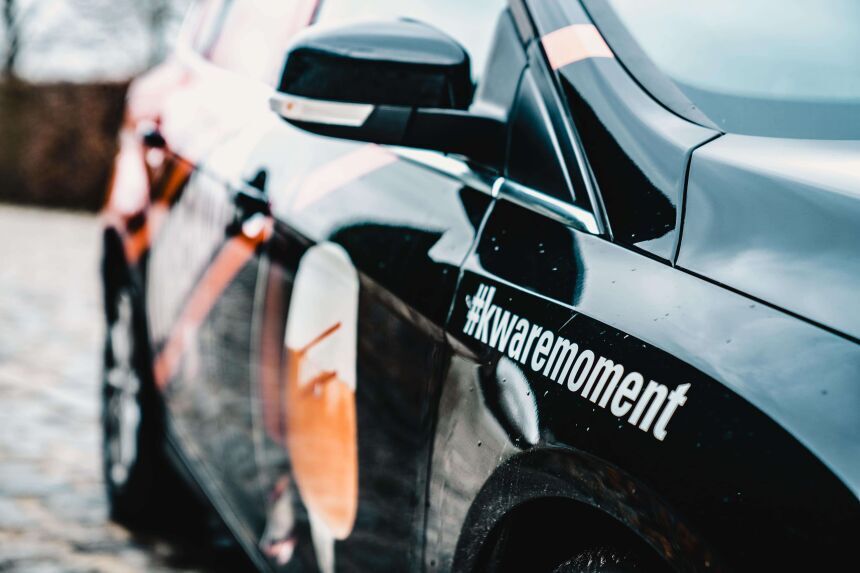 Zwarte sportwagen met #kwaremoment hashtag op de zijkant